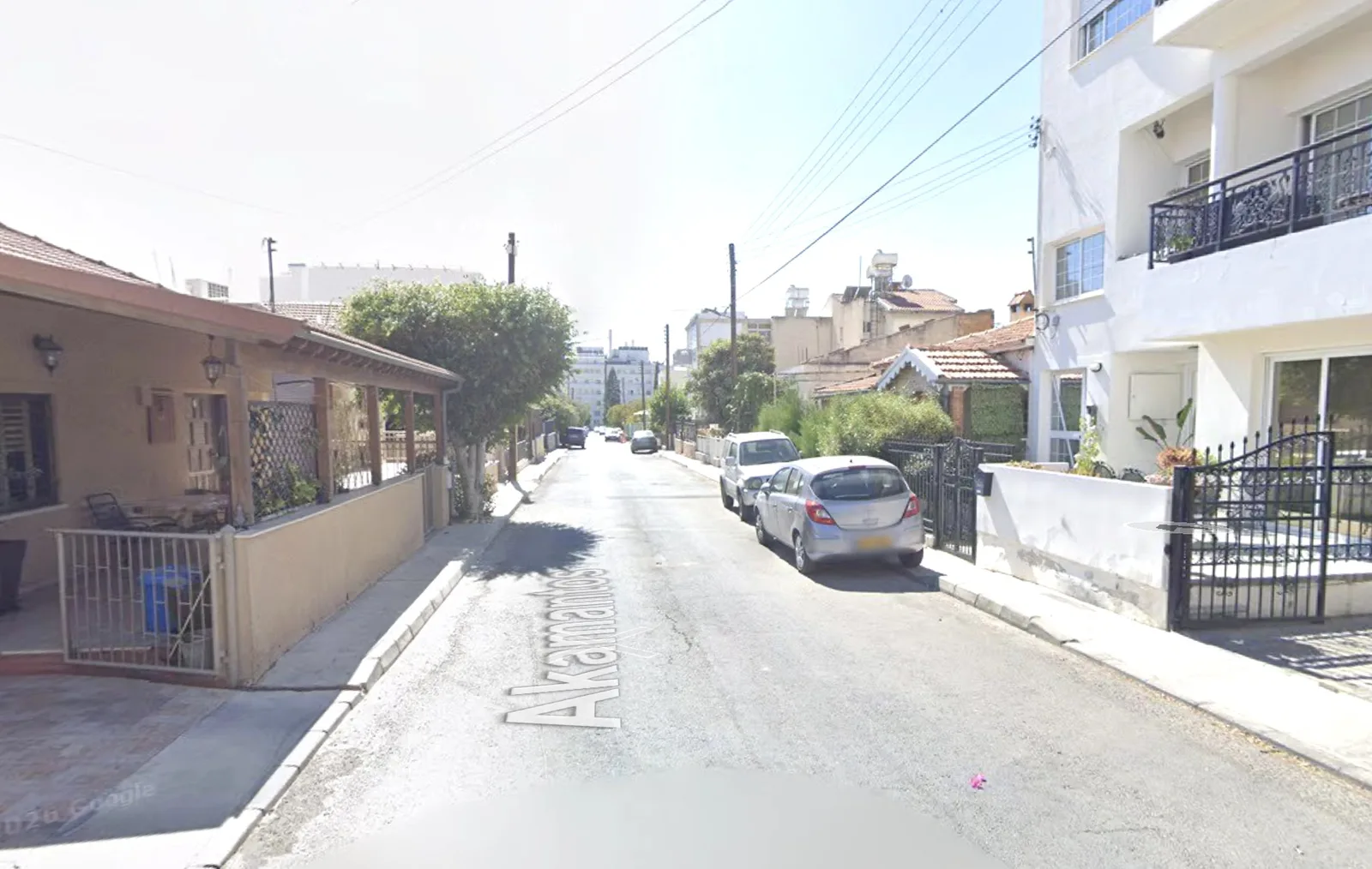 Η οδός Ακάμαντος σήμερα: σπασμένη άσφαλτος, αυτοκίνητα στο κράσπεδο, ουσιαστικά χωρίς πεζοδρόμιο