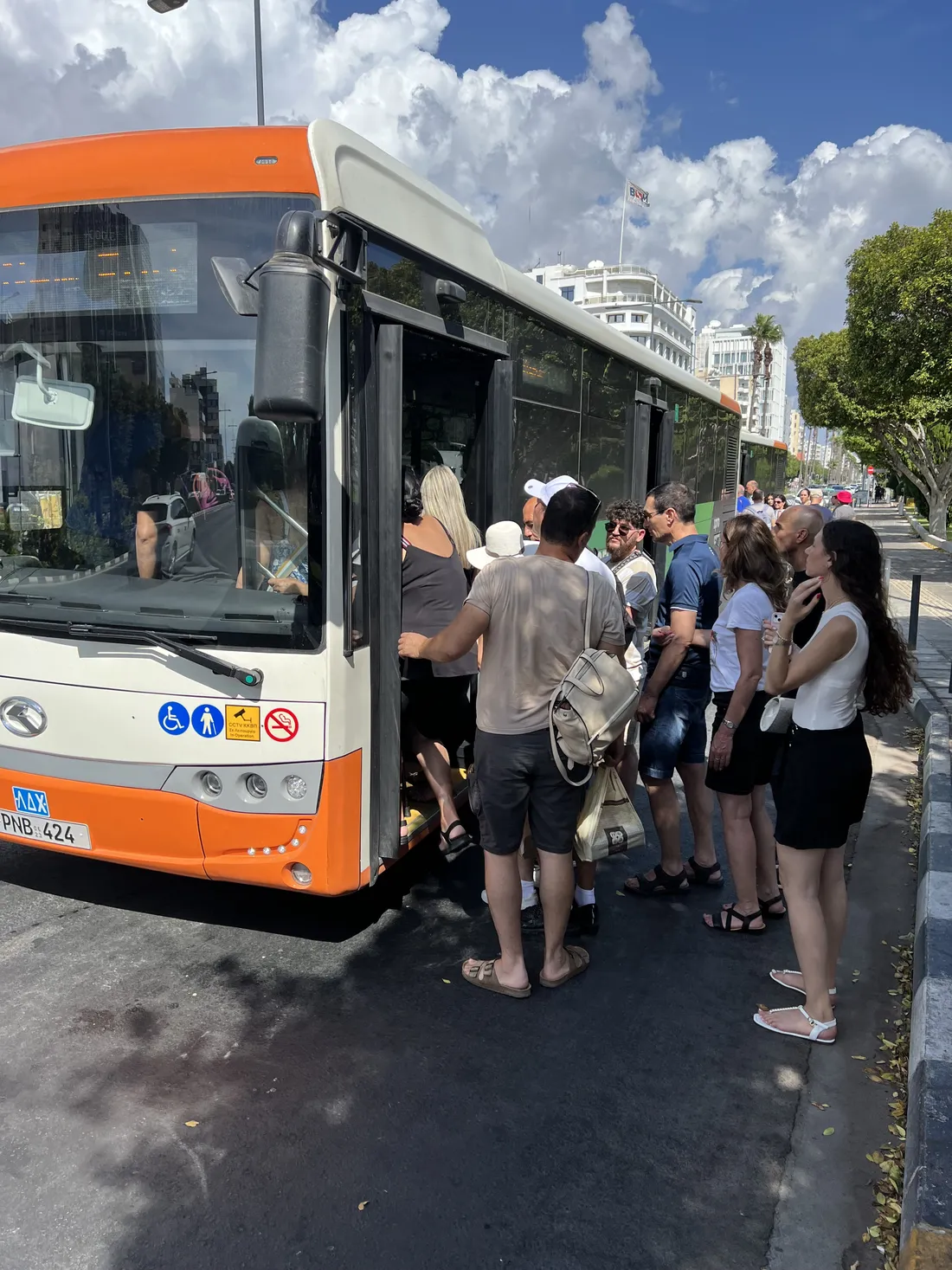 Κόσμος επιβιβάζεται σε λεωφορείο χαμηλού δαπέδου κατευθείαν από την άσφαλτο: ανάμεσα στο λεωφορείο και το κράσπεδο μένει μια λωρίδα οδοστρώματος