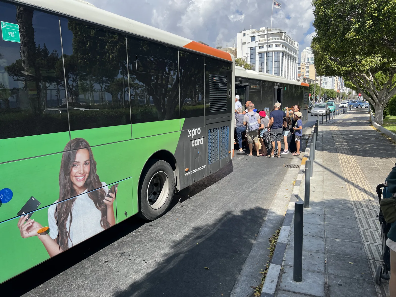 Το ίδιο λεωφορείο από πίσω: κενό πάνω από ένα μέτρο ανάμεσα στο πλάι του και το κράσπεδο, με ένα καροτσάκι να περιμένει στο πεζοδρόμιο